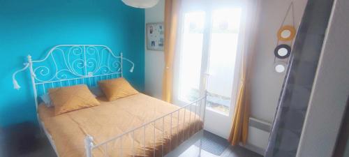 a bedroom with a bed with a blue wall at EntreLac&Océan1 - chambre d'hôtes chez l'habitant, Entrée et terrasse privée- cyclotouristes bienvenue in Aureilhan