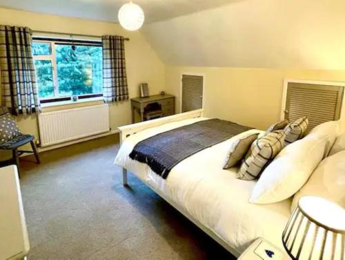 a bedroom with a large white bed and a window at 3 bed in Pontdolgoch 90709 in Aberhafesp