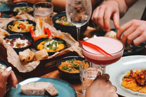 a group of people sitting at a table with a drink at Bazaar Boutique Residence in Budapest