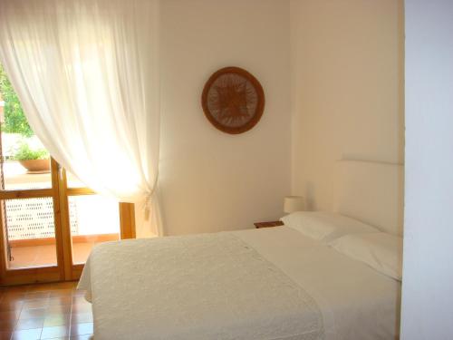 ein Schlafzimmer mit einem Bett und einer Uhr an der Wand in der Unterkunft Villetta Cinquale Versilia in Cinquale