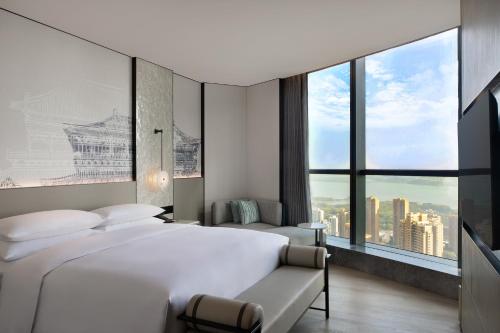 a bedroom with two beds and a large window at Wuhan Marriott Hotel Wuchang in Wuhan