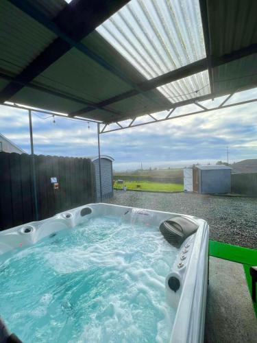 a jacuzzi tub sitting under an umbrella at Shepherds hut Greencastle in Omagh