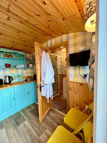 a kitchen with blue cabinets and a sliding door at Shepherds hut Greencastle in Omagh