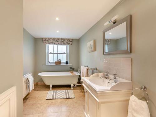 a bathroom with a tub and a sink and a mirror at 2 Bed in County Durham 90576 in Whittonstall