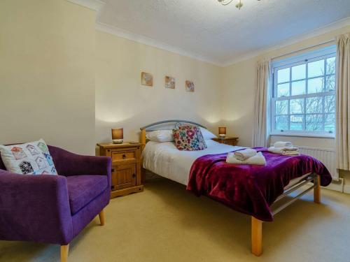 a bedroom with a bed and a chair and a window at 3 Bed in Richmond 90578 in Catterick Bridge