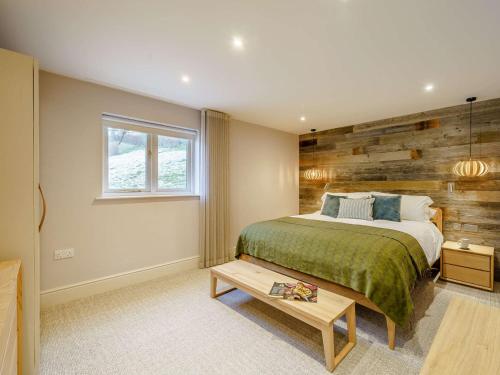 a bedroom with a bed and a wooden wall at 1 Bed in Ambleside 90636 in Ambleside