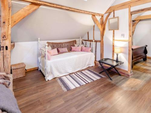 een slaapkamer met een bed met roze kussens en een piano bij 1 Bed in Loxwood 90733 in Loxwood