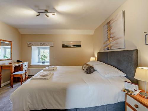 um quarto com uma grande cama branca e uma secretária em 3 Bed in Cosheston 90732 em Cosheston