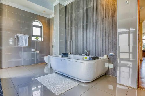 a large bathroom with a tub and a sink at Villa Tasha Luxury Suites, Lanseria in Johannesburg