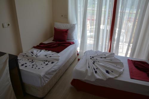 two twin beds in a room with a window at Yavuzhan Hotel in Side