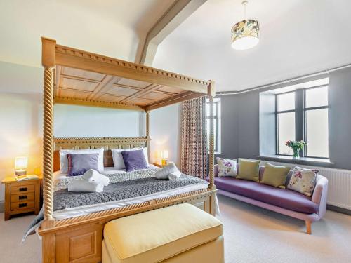 sypialnia z łóżkiem z baldachimem i kanapą w obiekcie 9 Bed in Porthmadog 90740 w mieście Talsarnau
