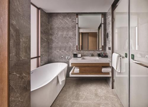 a bathroom with a tub and a sink at Crowne Plaza Chengdu Wuhou by IHG in Chengdu