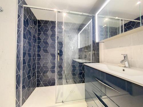 une salle de bain avec une douche en verre et un lavabo dans l'établissement Cannes - Basse Californie - 3 pièces, à Cannes