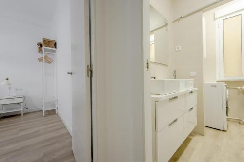 bagno bianco con lavandino e specchio di Elegante apartamento en el Centro de Madrid-Rastro a Madrid