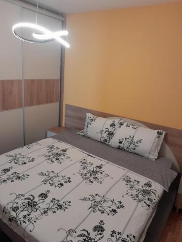 a bedroom with a bed with a black and white blanket at APARTMANS AJAN OHRID in Ohrid