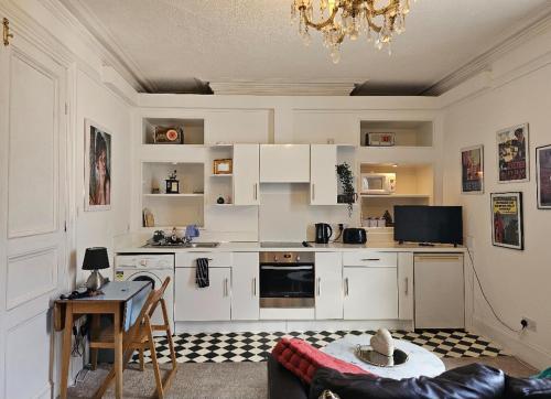 a kitchen with white cabinets and a table at City Centre Bolt Hole - Exeter in Exeter