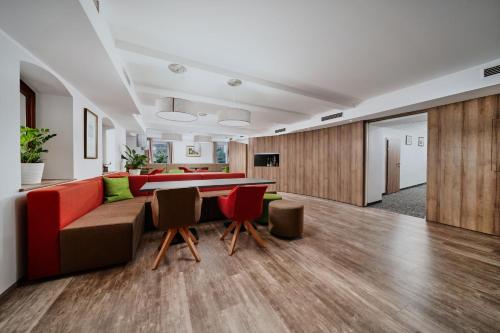 a living room with a couch and a table and chairs at Seehotel im Weyer in Gmunden