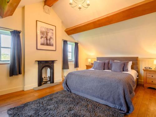 a bedroom with a bed and a fire place at 4 Bed in Blakeney 90589 in Awre