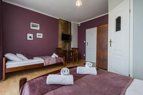 two beds in a room with two towels at Pod Horodkiem in Cisna