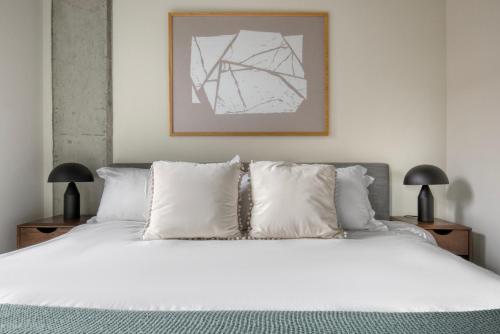 een slaapkamer met een bed met witte lakens en kussens bij River North 1br w gym pool nr riverwalk L CHI-1034 in Chicago