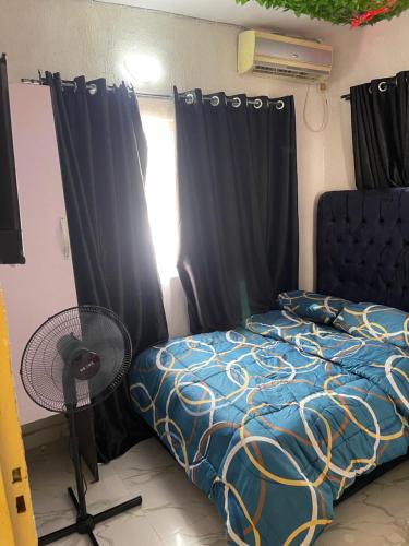 a bedroom with a bed and a window with curtains at bdream home / dreamz apartment in Agege