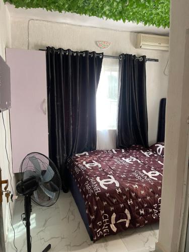 a bedroom with a bed with black curtains and a fan at bdream home / dreamz apartment in Agege