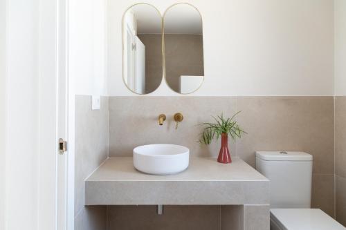 a bathroom with a white sink and a mirror at Ereza White Homes in Caleta De Fuste