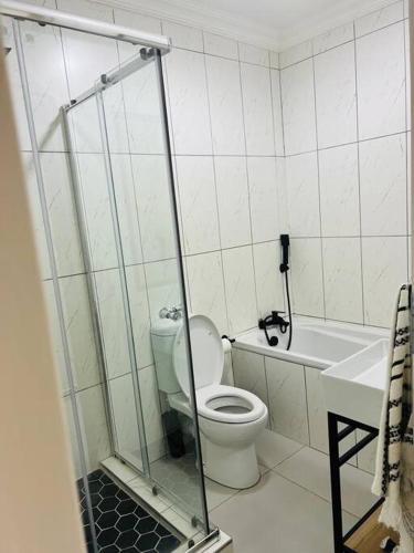 a bathroom with a toilet and a sink and a shower at Wanderlust 2-bedroom Apartment in Centurion