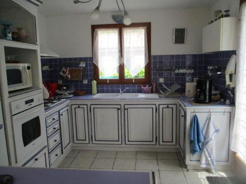 een keuken met een wastafel en een raam bij Le Mas Nany in Rocbaron