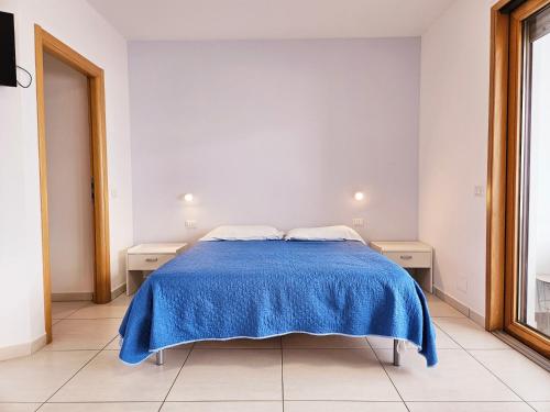 Camera bianca con letto e coperta blu di Dolphin's Home a Porto Torres