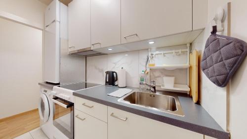 a small kitchen with a sink and a microwave at Modern studio in the heart of Geneva in Geneva