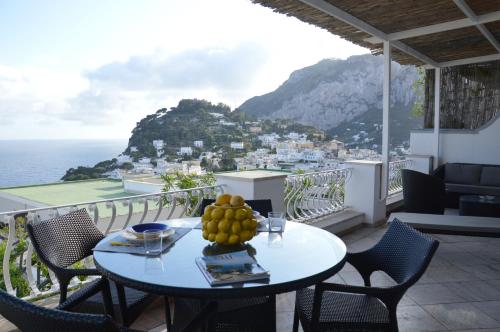 een tafel met een fruitschaal op het balkon bij Villa La Panoramica 3 camere 3 bagni in Capri