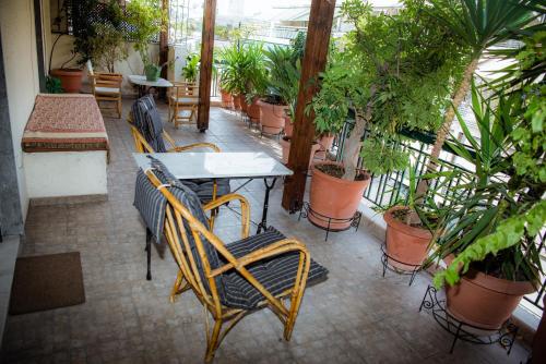 um pátio com uma mesa, cadeiras e plantas em Sophie's Penthouse in Athens em Atenas