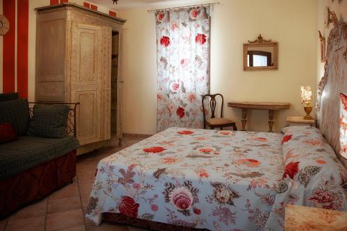 a bedroom with a bed with a flowered blanket at Agriturismo Forzello in Ariano nel Polesine