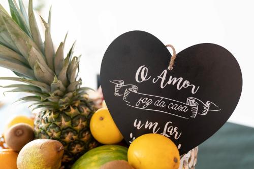 a basket of fruit with a heart sign on it at Villa Paraíso da Caparica in Charneca