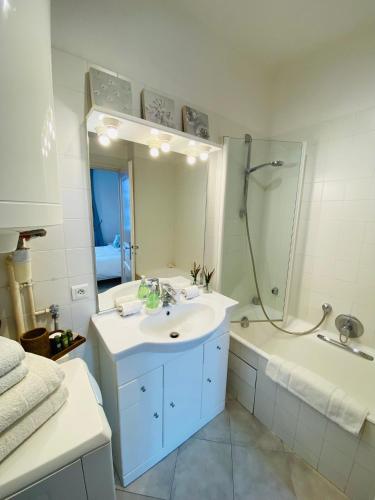 une salle de bain avec un lavabo, une baignoire et un miroir dans l'établissement Pimms Apartment, à Antibes