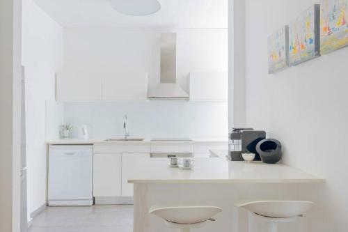 a white kitchen with a counter and a sink at Tiran Square Haven - Herzliya Pituach in Herzliya B