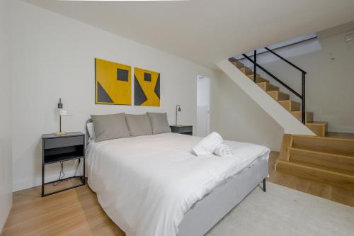 a bedroom with a white bed and a staircase at Modern Apt & Cool interior design a 20 metros del Retiro in Madrid