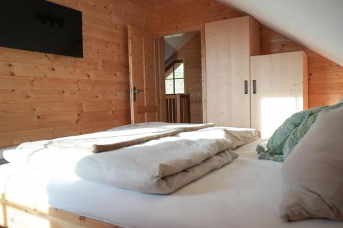 un grupo de almohadas sentado en una cama en una habitación en Steindl Hütte, en Deutschfeistritz