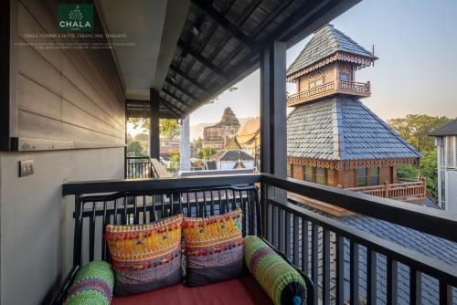 a balcony with pillows and a chinese tower in the background at Chala Number6 in Chiang Mai