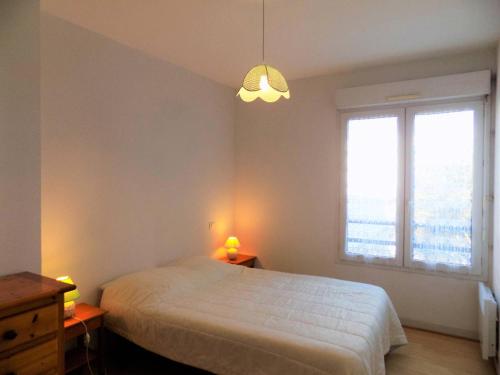 een slaapkamer met een wit bed en een raam bij Royan - APPARTEMENT avec EMPLACEMENT IDEAL - terrasse - garage privatif in Royan