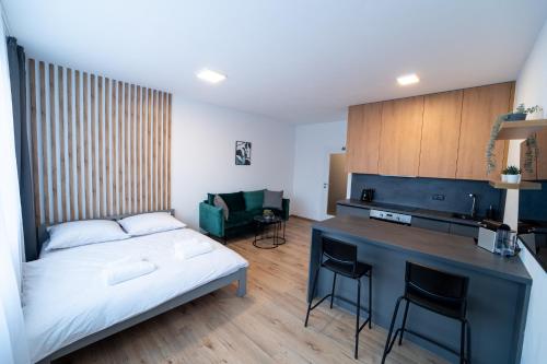 een slaapkamer met een bed en een bureau met stoelen bij Apartmán Chrudimpark in Chrudim