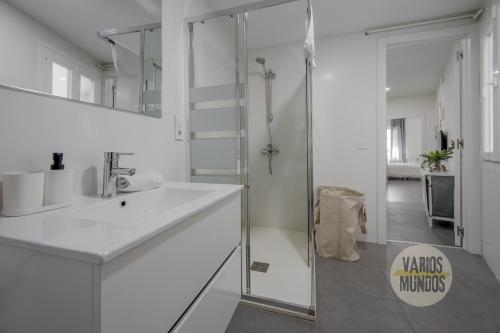 a white bathroom with a sink and a shower at Excuisite New apt en Gran Via para 5pax in Madrid