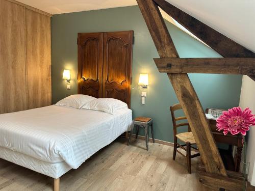 1 dormitorio con 1 cama, 1 silla y 1 mesa en La Ferme de Maraval, en Cénac-et-Saint-Julien