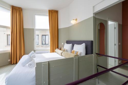 sypialnia z dużym łóżkiem i oknem w obiekcie The Black Pants w Antwerpii