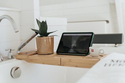 a laptop on a cutting board with a plant and a cup at Maison Héromie - vakantiewoning Damme - 8 personen in Damme