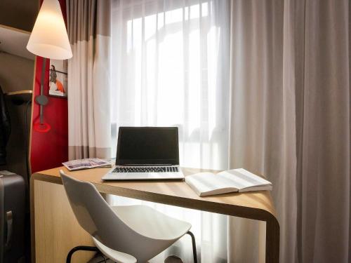 a laptop computer sitting on a desk with a chair at ibis Lille Centre Grand Palais in Lille