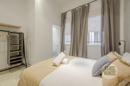 1 dormitorio con 1 cama blanca grande con almohadas en Stylish Loft with 2 beedrooms en el Centro - La Latina, en Madrid