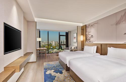 成都市にあるCrowne Plaza Chengdu Wuhou by IHGのベッド2台と薄型テレビ付きのホテルの部屋