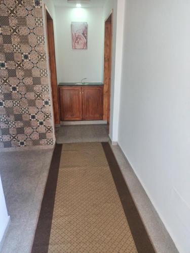 a hallway with a wooden door and a rug at dar el souk in Djerba
